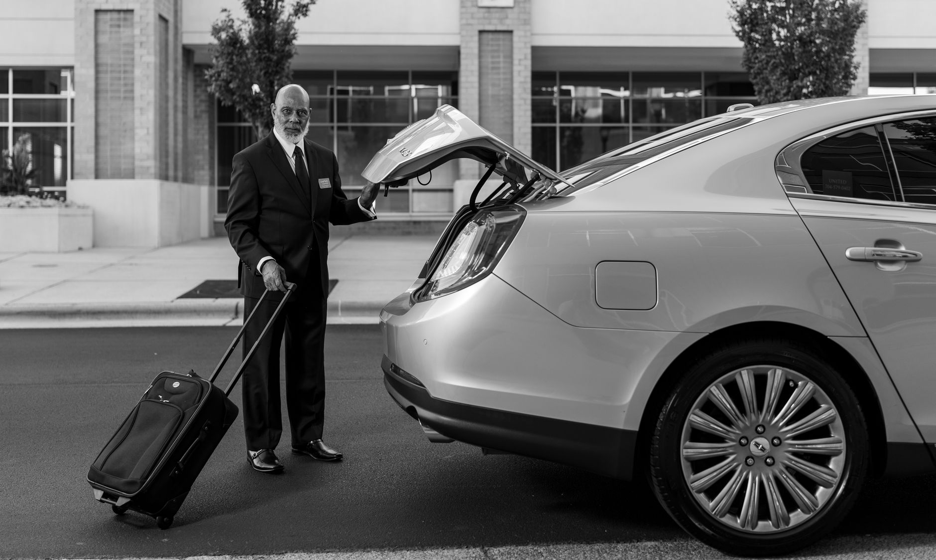 Chauffeur loading luggage for a corporate traveller